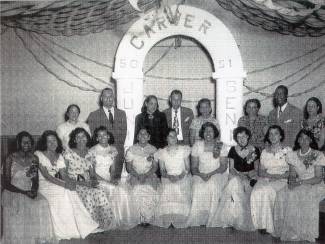 Photo of 1950-1951 Carver High School Junior-Senior Prom; girls seated in front in formal dress, administrators standing in back