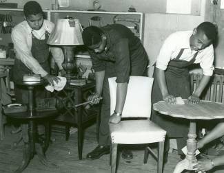 3 students of Carver High School shop class sanding tables and nailing a chair