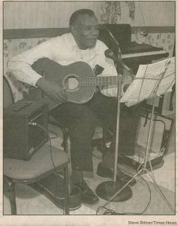 Man playing guitar with microphone stand