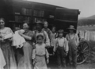 Large family poses for a photo standing in front of the bookwagon with books behind them