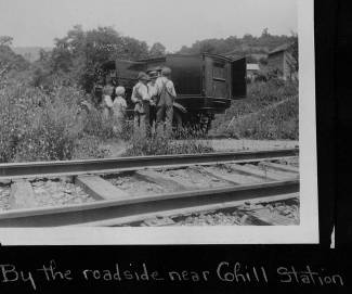 Book wagon parked near train track with family looking through books