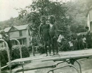 Two young black children playing near swimming pool 