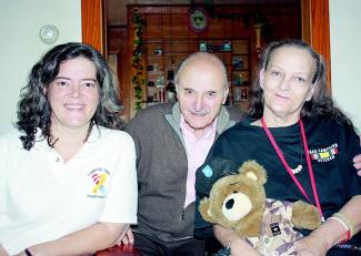 Photo of trio, 1 women holding teddy bear; Germaine Broussard, Robert Fratkin and Vickie Doolan-Fearon