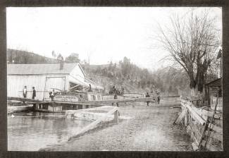 Loaded canal boat at the Williamsport Lock (Lock 44); building near lock with several men about in the area