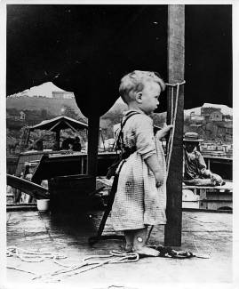 Young boy on Canal boat wearing a safety harness