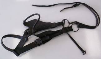 Mule bridle with blinkers attached to the cheek pieces and a loose ring snaffle bit with clip on reins.