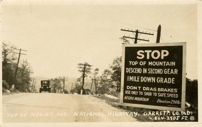 Postcard over peak of Negro Mountain at road with car approaching; circa 1920s