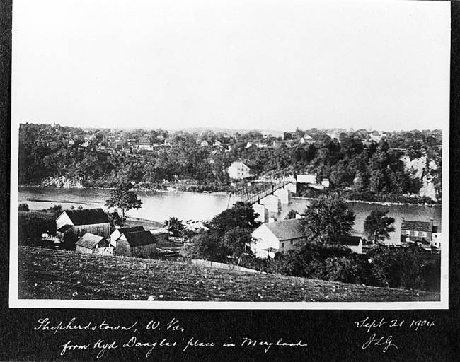 Photograph of community around Potamac River looking at the bridge; Text written says "Shepherdstown, W.Va. from Kyd Douglas’ place in Maryland." Sept 21 1904. JLG