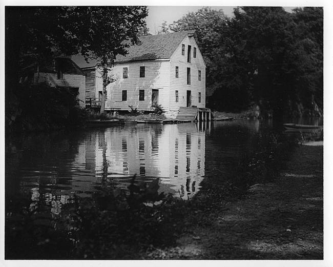 Charles Mill near canal. White building with loading dock near river bank