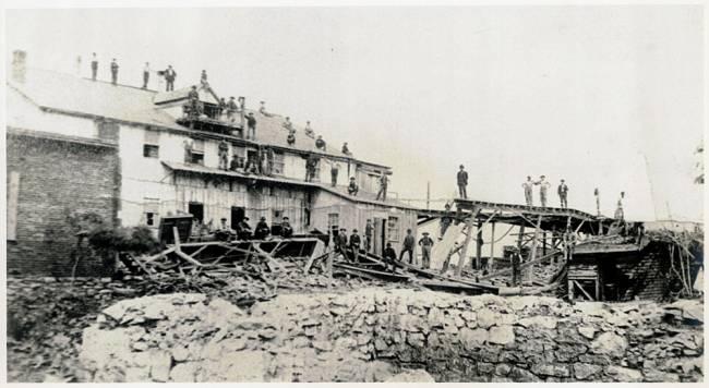 The Chair Factory after the 1889 flood. 30+ men seen standing on various levels of roof top and on ground making repairs