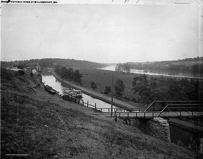 At Bollman's company bridge, boat in canal with Potomac River in background, circa unknown