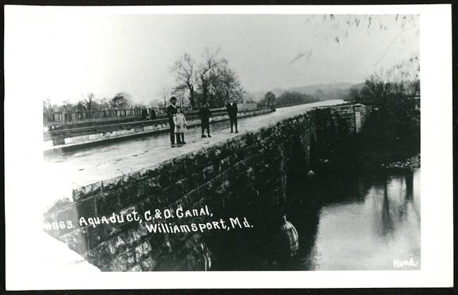 Conococheague Aqueduct, a stone bridge; family of 4 standing on bridge