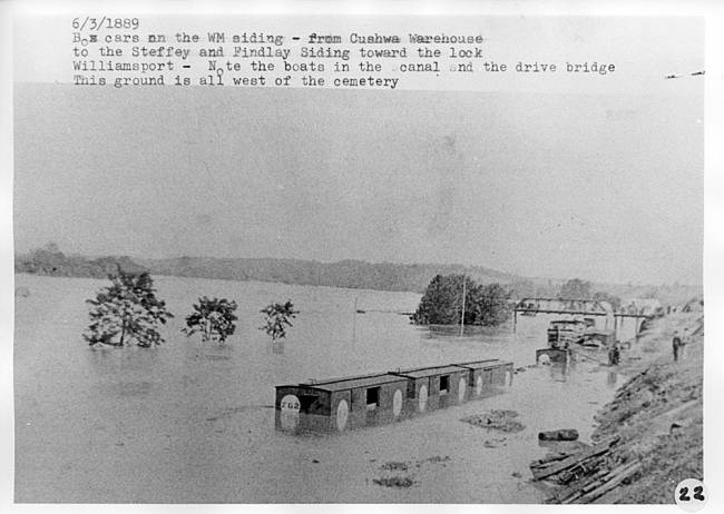 Flooded canal, box cars covered in water, bridge is seen in far ground near Cushwa warehouse, 1889