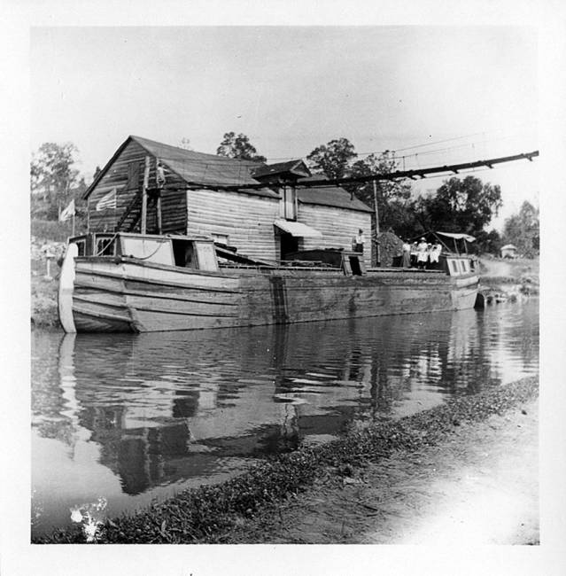 Boat in canal, wharf here was known as Sharpsburg Landing before it took on the name Snyders Landing; family can be seen at back of canal boat
