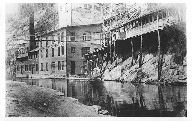 Close up view of Round Top Cement Mill along canal; Mill is several stories high