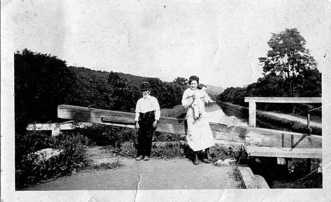 Photograph of Thomas Donegan, Ann Gotner, and Anna Kent resting on a beam