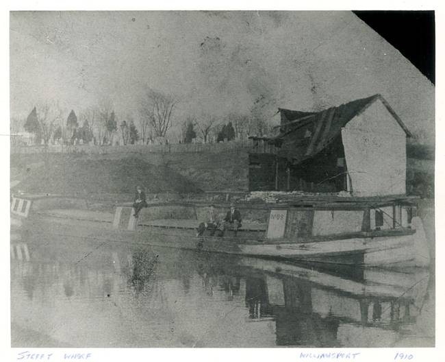 Near the Steffey & Findlay Coal Company Wharf, a couple of men and a boy sitting on a loaded canal boat