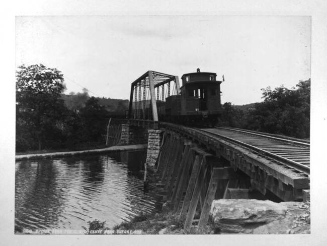 Train bridge with loaded train crossing over bridge at Cherry Run, WV; circa unknown