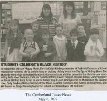 Newspaper clipping of school room with teacher and children; students celebrate black history