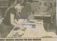 Newspaper article about Quilt Squares created for New Museum; girl arranging squares