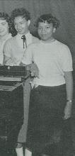 Cropped image of young black woman standing behind a piano