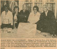 Newspaper clipping of 5 people holding an anniversary cake