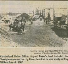 Newspaper article about area of Cumberland in 1907; horses on a street road with houses in the background