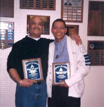 Two people holding plaques in front of them posing for photograph