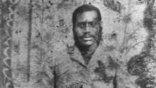 Black and white photo of black man in tailored jacket circa 1910s