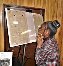 Girl reading article from Black History Month display at  Cumberland, Maryland Metropolitan African Methodist Episcopal (AME) Church