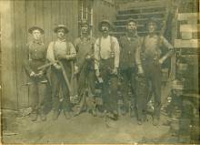 6 miners standing for picture with tools in hand