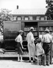 Book wagon on country road; women and children looking through books