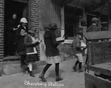 Group of people walking out of station reading books