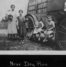 Children posing for picture with books outside of book mobile near Dry Run