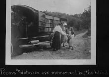 Book wagon on country road; women and children looking through books