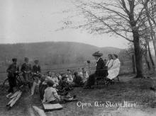 Children gather on countryside listening to story hour