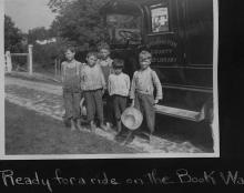 Book wagon on country road; young boys pose for picture