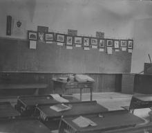 School room with desks and blackboard; deposit box with WCFL in the front