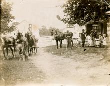 Book wagon with 2 horses with man, woman and young children getting books