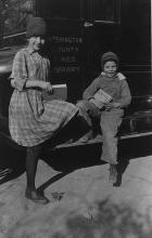 Two children pose in front of bookwagon circa 1923