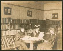 3 women seated at round table in Boonsboro Library reading books;1907