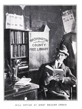 Man sitting in deposit station reading a book; Deposit box print states Washington County Free Library