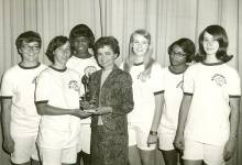 Photo of students receiving award trophy from teacher