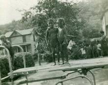 Two young black children playing near swimming pool 