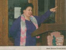 Photo of woman speaking at podium with National Park Service logo on front of podium