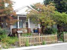 Photo of rancher home with picket fence in front