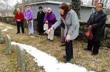 Photo of men and women looking over gravestones with snow on grown in Boonsboro MD 2014