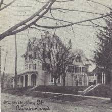 Black & white postcard of 3 story home on street; text says "Washington St Cumberland"