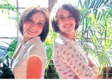 2 young women standing in front of palm plants - Natasha and Josinda Feldstein