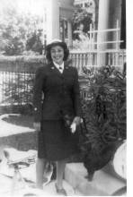 Casual photo of Jane Schwab standing in formal military uniform with skirt
